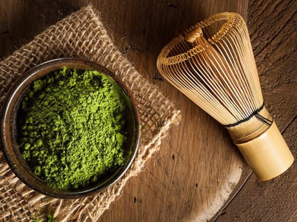 Mighty Leaf Organic Matcha Powder in a bowl with traditional wooden whisk enjoyed regularly to boost immune system and enhance well being.